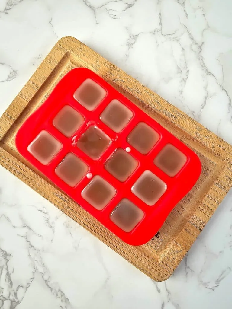 Vanilla Homemade Lotion Bar Step 5 - A red tray with ice cubes on it.