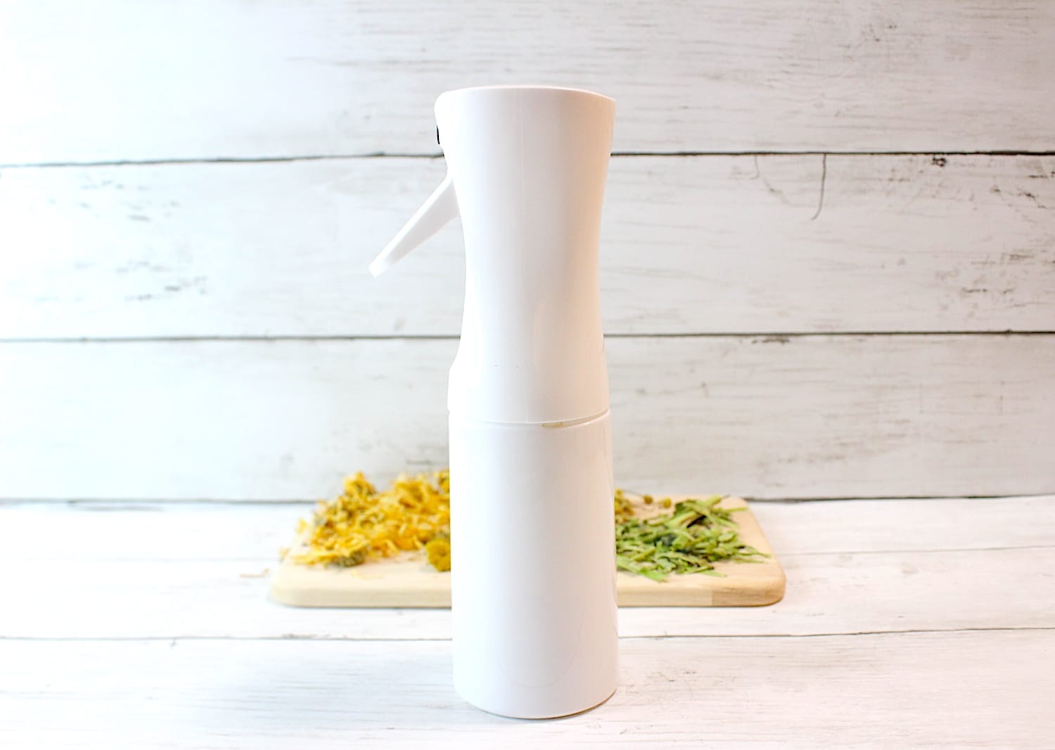 A white bottle of Jewelweed Spray on top of a wooden cutting board.