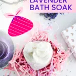 A jar of oat and lavender bath soak is nestled in pink shredded paper, with lavender sprigs and a heart-patterned gift box nearby. Text reads "Easy Gift! Oat Bath Soak.